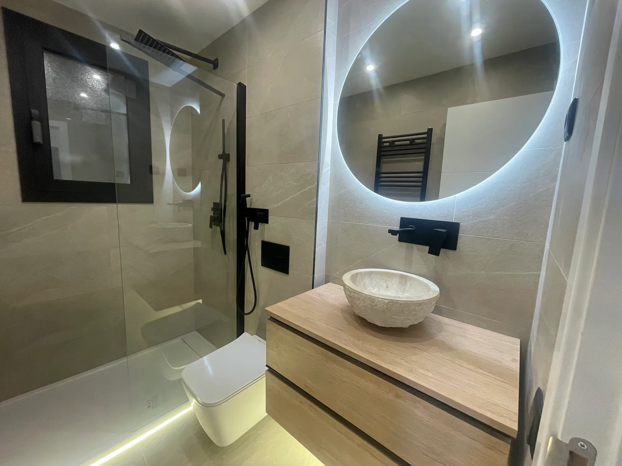 Baño reformado con revestimiento de piedra natural.